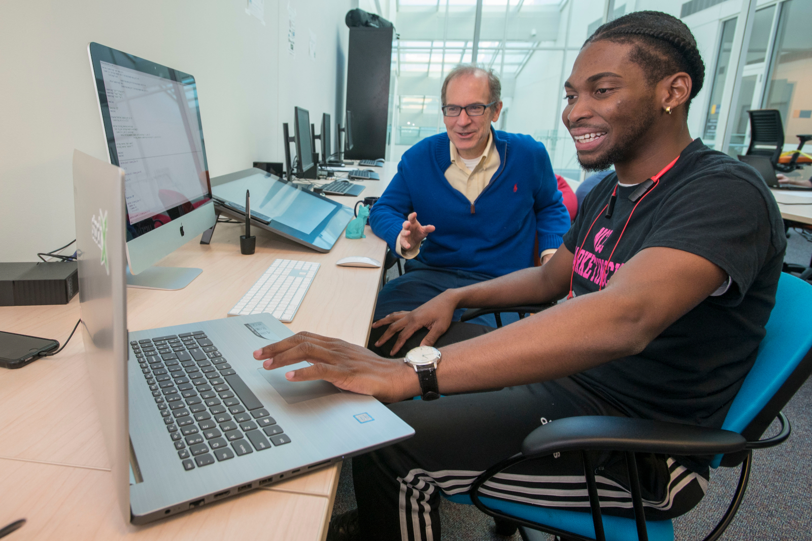 Professor Phillip Bradford meeting with a student about his computer science project at Uconn Stamford on Oct. 17, 2018. (Sean Flynn/UConn Photo)